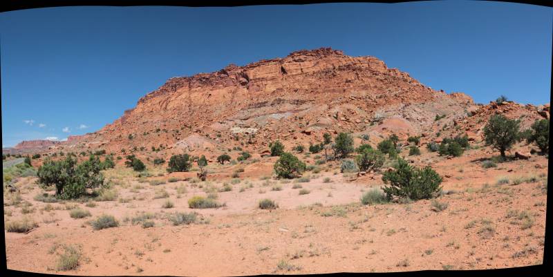 Desert rocher rouge montagne ciel clair jour naturel largeur sauvage desole lointain aride cenical sud ouest amerique L'image que vous avez partagée semble montrer une scène de paysage. Au premier plan, il y a un environnement désertique avec peu de végétation et un ciel clair au-dessus. Au-delà, il y a une colline ou une petite chaîne de montagnes avec des formations rocheuses bruns orangés, ce qui suggère qu'il pourrait s'agir d'une région connue pour ses caractéristiques géologiques distinctives. Le terrain semble sec et ouvert, ce qui est typique de nombreux environnements désertiques. Le soleil apparaît en Train de briller clairement, faisant ombrer le sol et donnant à l'image une lueur chaude. Il n'y a aucune écriture visible ni des structures artificielles distinctives qui peuvent être discernées à partir de cette description.