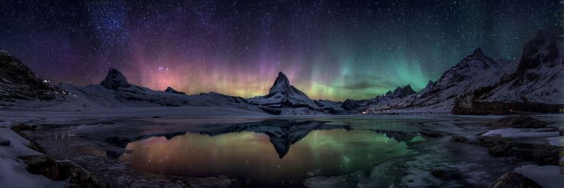 Night sky mountain lake reflection snow aurora clouds stars rocks water ice winter nature outdoors scenery atmosphere In the foreground, a serene lake reflects the vibrant colors of the aurora borealis, creating a mesmerizing mirror effect. The sky above is a deep, dark blue, dotted with countless stars. The aurora borealis, or Northern Lights, dances across the sky in shades of green, purple, and pink. The landscape is dominated by snow-covered mountains, their peaks sharp and jagged against the night sky. The foreground is a mix of rocks and ice, with the reflection of the lights adding a magical touch to the scene. In the distance, a small town or settlement is faintly visible, its lights twinkling like stars.