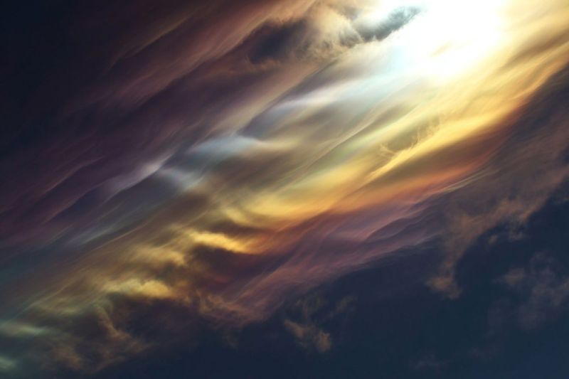 Ciel nuages atmosphere meteo nature soleil journee luminosite reflexion ombre texture environnement meteorologie L'image présente un ciel dramatique et coloré rempli de nuages. Les nuages sont superposés et semblent être illuminés par une source de lumière brillante, probablement le soleil, qui projette une chaleur douce sur la scène. Les nuages sont un mélange de teintes profondes et sombres et de nuances plus claires et pastel, créant un contraste saisissant. Le ciel passe des tons sombres, presque noirs au bas, aux couleurs plus claires et vibrantes vers le haut, où se trouve la source de lumière. Les nuages ont diverses formes et tailles, certains apparaissant effilochés et d'autres plus denses et texturés. L'effet global est celui d'un ciel magnifique, dynamique et en constante évolution.