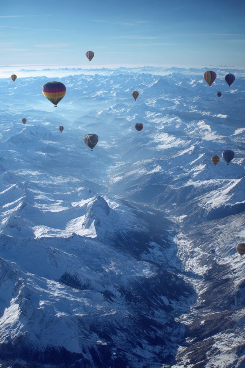 Montagnes ciel aventure voyage nature neige hiver nuages air exploration vacances recreation atmosphere distance chaud ballons aerien altitude bleu Un groupe de montgolfières colorées flotte dans le ciel au-dessus d'une vaste chaîne de montagnes enneigées. Les montagnes sont escarpées et majestueuses, avec des pics s'élevant brusquement dans le ciel. Le ciel est clair et bleu, avec quelques nuages filiformes éparpillés. Les montgolfières sont de diverses couleurs, notamment rouge, jaune, bleu et orange, et elles sont réparties dans le ciel, créant une scène belle et sereine. Les montagnes sont couvertes de neige, et la neige réfléchit la lumière du soleil, créant un effet étincelant. L'atmosphère générale est paisible et tranquille, avec les montgolfières ajoutant une touche de fantaisie et d'émerveillement à la scène.