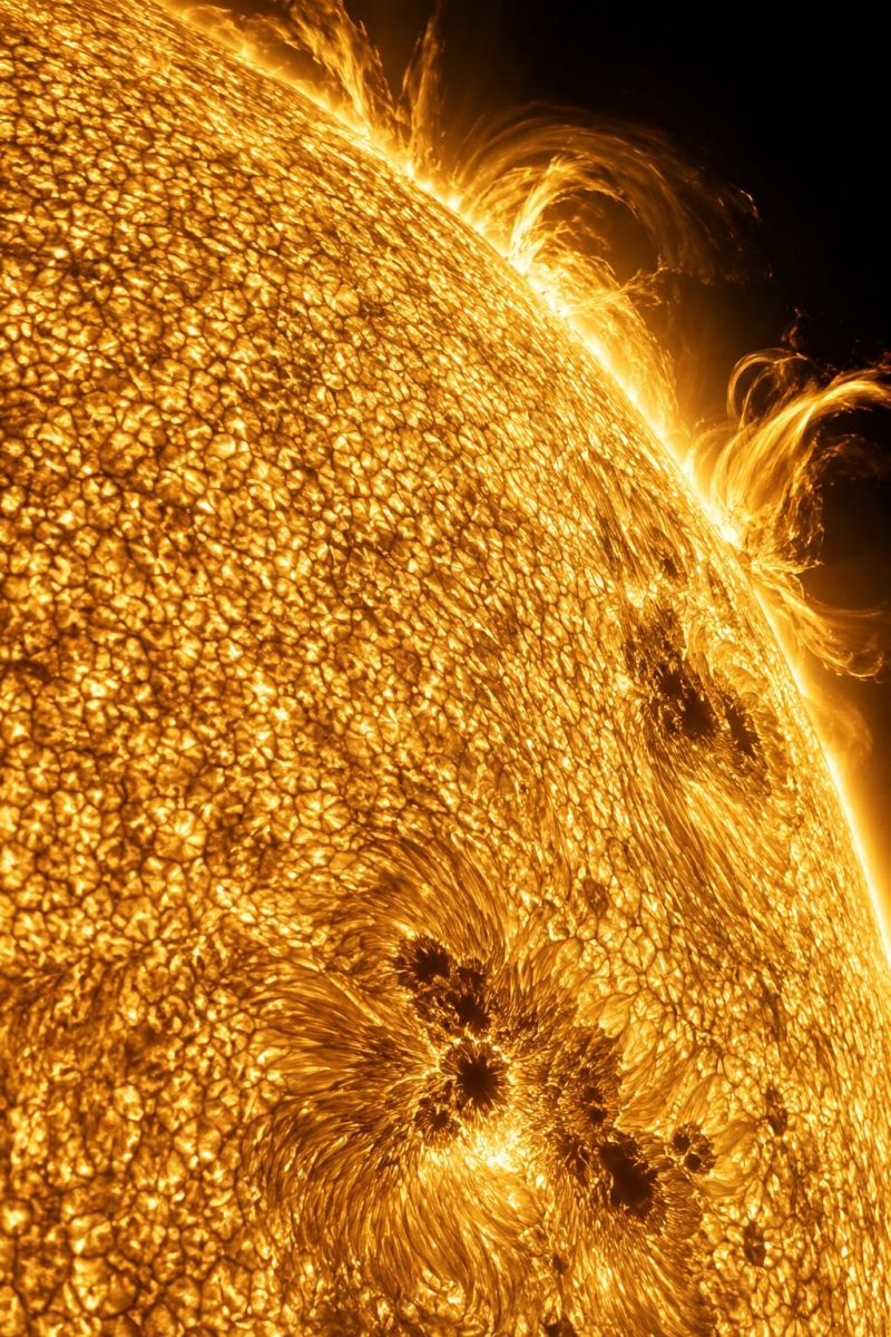 Sun solar star space astronomy cosmos universe heat energy radiation atmosphere surface texture pattern cracks waves brightness glow dark The image showcases the surface of the Sun, displaying a golden, textured pattern resembling a honeycomb. The surface is uneven, with some areas appearing darker and others lighter, creating a dynamic and vibrant appearance. There are several darker spots scattered across the surface, which are likely sunspots. The edges of the Sun are slightly blurred, transitioning into a dark background, emphasizing the intense brightness of the Sun's surface.